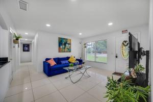 ein Wohnzimmer mit einem blauen Sofa und einem TV in der Unterkunft House in Tampa with Private Pool and more in Tampa