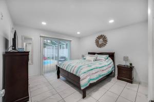 1 dormitorio con cama y espejo en la pared en Cozy Family Home in Tampa with Private & Heated POOL, Pool table and Kids Play Area en Tampa