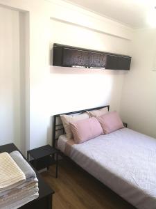 1 dormitorio con 1 cama con almohadas rosas en Apartamento Fração AX, en Esposende