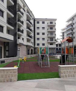 un parque infantil en medio de un complejo de apartamentos en Amfora Suite, en Trebinje