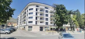 un edificio blanco con coches estacionados frente a él en Amfora Suite, en Trebinje
