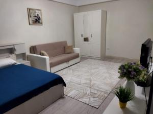 a living room with a bed and a couch at City House in Aktau