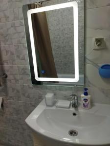 uma casa de banho com um lavatório e um espelho em City House em Aktau