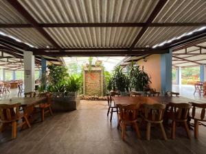 a restaurant with wooden tables and chairs and plants at Senderos de Sirivana in Yopal