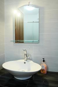 ein weißes Waschbecken im Bad mit Spiegel in der Unterkunft Giota's Gasthaus in Zakharo