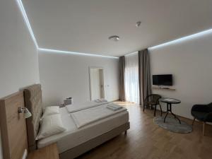sypialnia z łóżkiem, biurkiem i telewizorem w obiekcie Evita Apartmani Šibovska w mieście Prnjavor
