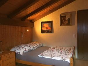 a bedroom with a bed and a picture on the wall at Ferienwohnung Interlaken/Wilderswil in Wilderswil