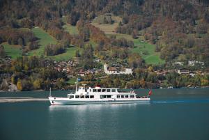 a boat on a lake with a town in the background at Ferienwohnung Interlaken/Wilderswil in Wilderswil