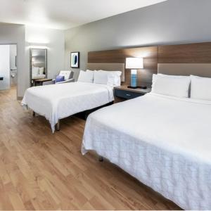 um quarto de hotel com duas camas e uma secretária em Candlewood Suites - Muskogee, an IHG Hotel em Muskogee