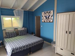 a bedroom with a bed in a blue room at Chez Rustine et Pompette in Saint-François