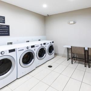 uma lavandaria com duas máquinas de lavar roupa e uma mesa em Candlewood Suites - Muskogee, an IHG Hotel em Muskogee