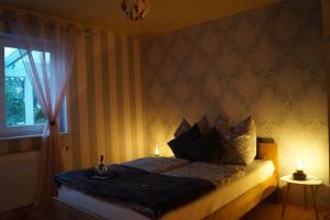 una camera da letto con un letto con due candele sopra di Ferienwohnung Orchidee Eckenhagen a Reichshof 