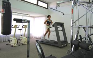 a woman standing on a treadmill in a gym at Corallia Beach Hotel Apartments in Coral Bay