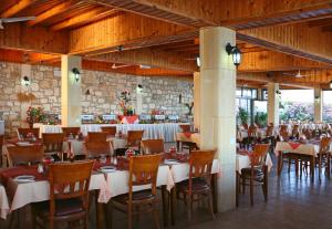 a dining room with tables and chairs in a building at Corallia Beach Hotel Apartments in Coral Bay