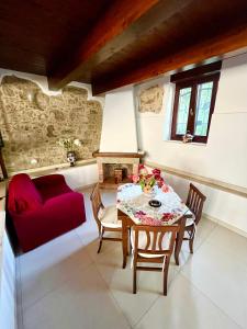 un soggiorno con tavolo e divano rosso di IL GIARDINO DI ATHENA a Paestum