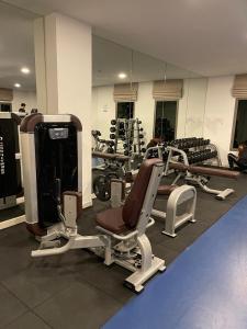 a gym with several tread machines and a mirror at Arcadia Continental Pattaya in Pattaya South