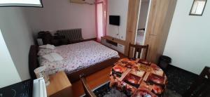 a small bedroom with a bed and a table at Apartments Nebojša in Soko Banja