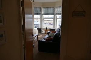 a living room with a couch and a window at ShellSeekers Holiday Apartment, Llandudno in Llandudno