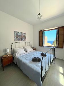 een slaapkamer met een bed en een raam bij Ritsos Family Apartment in Monemvasia