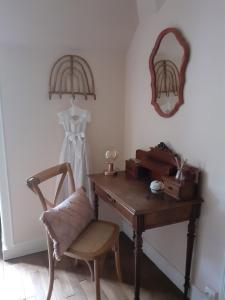Habitación con escritorio, silla y espejo. en Le Peu'ty Cottage, en Fougères-sur-Bièvre
