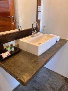 a bathroom counter with a white sink and a mirror at Vila Bless 4 bedroom Vila with pool, garden and beach tennis court in Prea