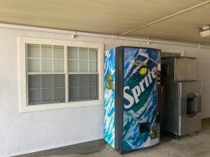 a cola vending machine sitting next to a building at Super 8 by Wyndham Terrell in Terrell