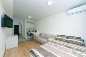 a bedroom with a bed and a couch and a kitchen at Smart House 7 in Kyiv