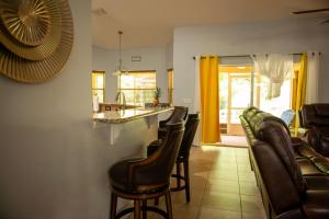 uma sala de estar com um bar e algumas cadeiras em Charming vacation home in Port St Lucie. em Port Saint Lucie