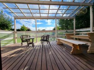 a wooden deck with a bench and a table and chairs at Domek 105 in Gietrzwałd