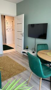 ein Wohnzimmer mit einem Tisch und einem grünen Stuhl in der Unterkunft Grochowska Apartment in Warschau
