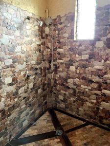 baño con pared de ladrillo y ventana en Casa Taller zapoteca Huella Carmín en Teotitlán del Valle