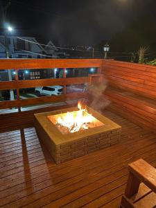 un focolare su una terrazza di legno di notte di Pousada Chateau Colinas a Campos do Jordão