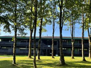 un edificio de oficinas con árboles delante de él en Ferienwohnung Studio 5, en Siegsdorf