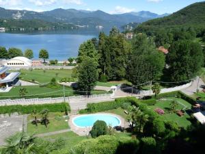 GozzanoにあるApartment Lidoのスイミングプールと湖のある公園の景色を望めます。