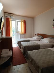a hotel room with three beds and a window at Hotel Holiday in Poreč +80 photos