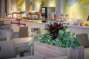 a restaurant with tables and chairs and a counter at Hotel Marco Polo in Caorle