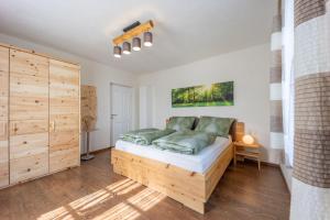 um quarto com uma cama de madeira e pisos de madeira em das "Ferienhaus Eibiswald" im Schilcherland em Eibiswald