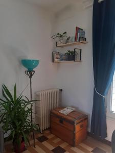 una sala de estar con una planta y una cortina azul en Le Peu'ty Cottage, en Fougères-sur-Bièvre