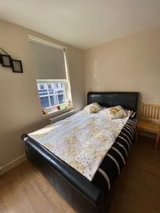 a bed in a bedroom with a black bed frame at Stefi apartment room in Edgware