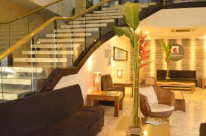 a living room with a couch and a staircase at Hotel Ciudad Bonita in Bucaramanga