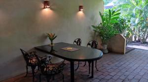 a table and chairs in a patio with plants at Casitas El Escondite Playa La Ropa in Zihuatanejo