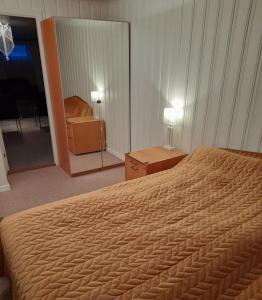 Habitación de hotel con cama y espejo en apartment on the first floor of the house en Skien