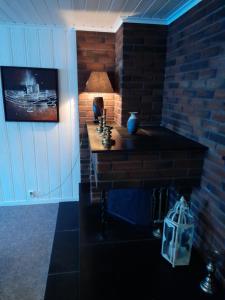 a room with a brick fireplace with a lamp on it at apartment on the first floor of the house in Skien