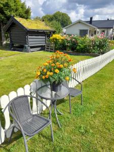 a table and chairs with flowers on a yard at apartment on the first floor of the house in Skien