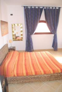 a bedroom with a large bed with blue curtains at Oleandro Ocean Apartment in Santa Maria