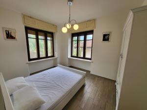 BussolenoにあるBig appartement - 9 guests - Air Conditionning and Courtyardのベッドルーム1室(白いベッド1台、窓2つ付)