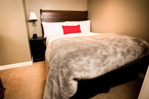 a bedroom with a large bed with a red pillow at Sundial Hotel in Whistler