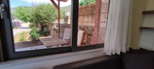 a window with a view of a patio with a bench at Romantica Apartments in Falasarna