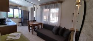 a living room with a couch and a kitchen with a table at Romantica Apartments in Falasarna