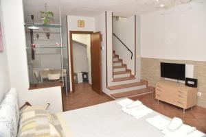 ein Schlafzimmer mit einem Bett, einem TV und einer Treppe in der Unterkunft Casa Emanuela, Il nostro Nido d'amore in Casalgrande